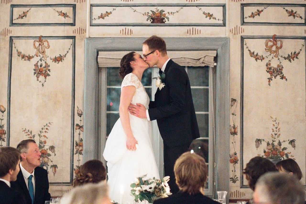 Brudepar som står på stolene og kysser foran sine gjester