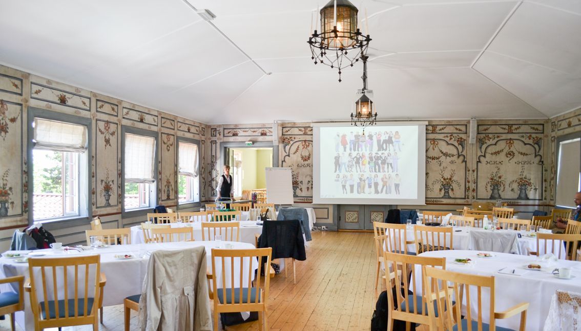 Festsalen er dekket til møte, hvor det er en moderne projektor. 