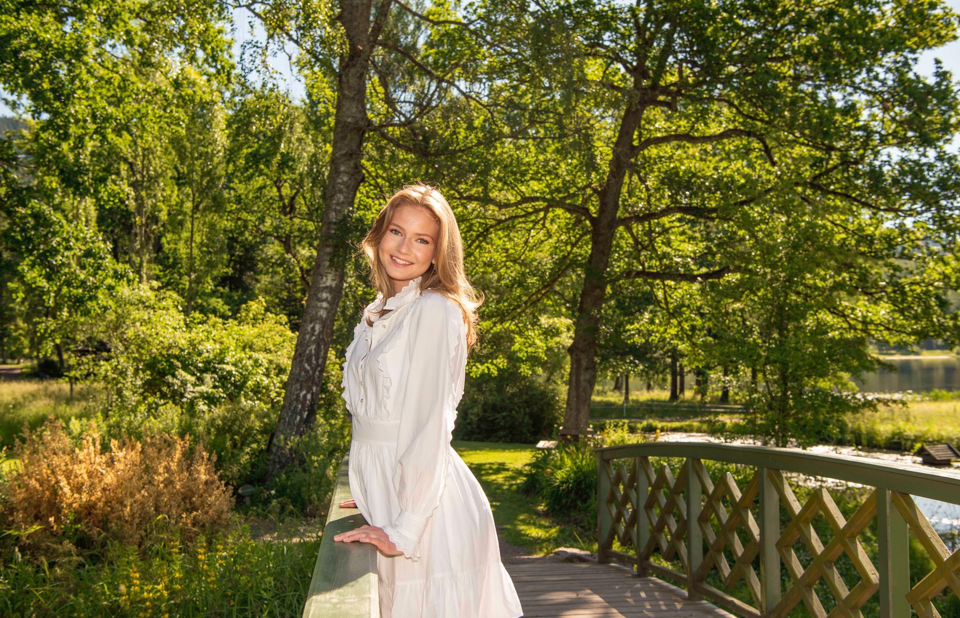Konfirmant som står ute i de flotte grønne omgivelsene hos Bogstad Gård
