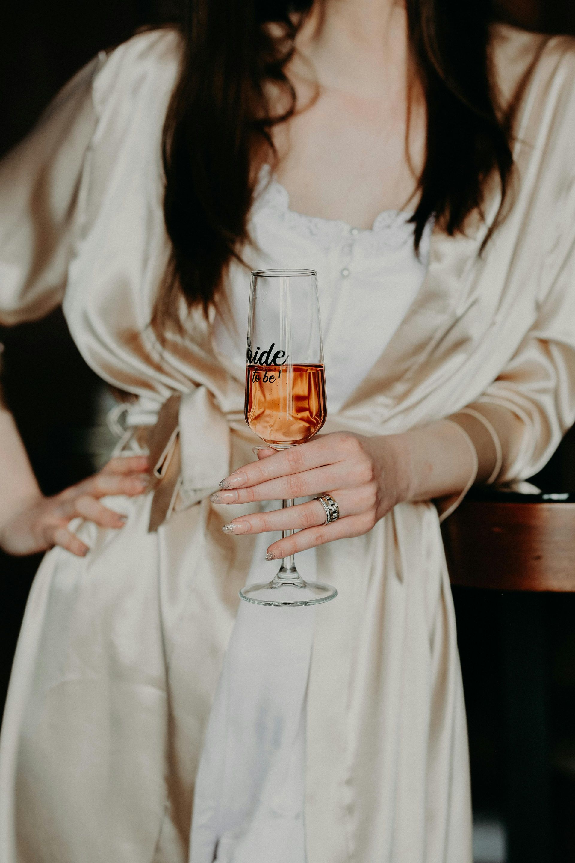 Brud i en stroppeløs hvit kjole og brudgom i en svart dress holder hender og går sammen.