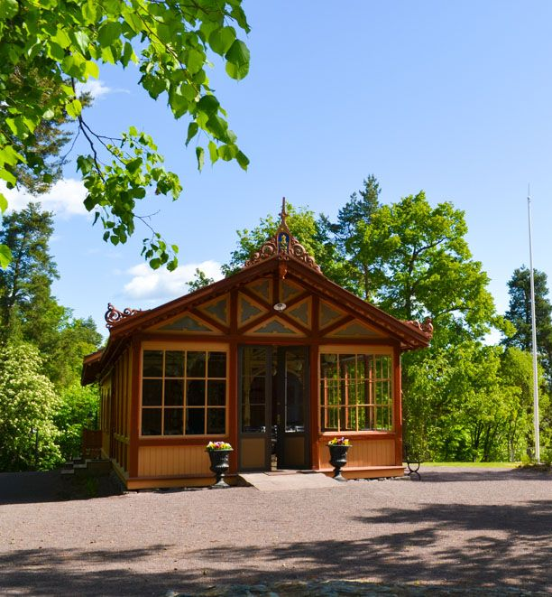 Dekkede bord til middag; trevegger, grønne vindusrammer og levende lys.