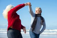 elderly couple exercising on the beach