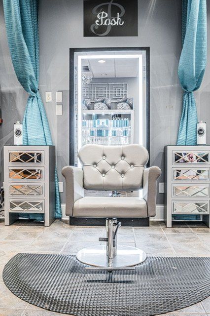 There is a chair in the middle of the room in a salon.