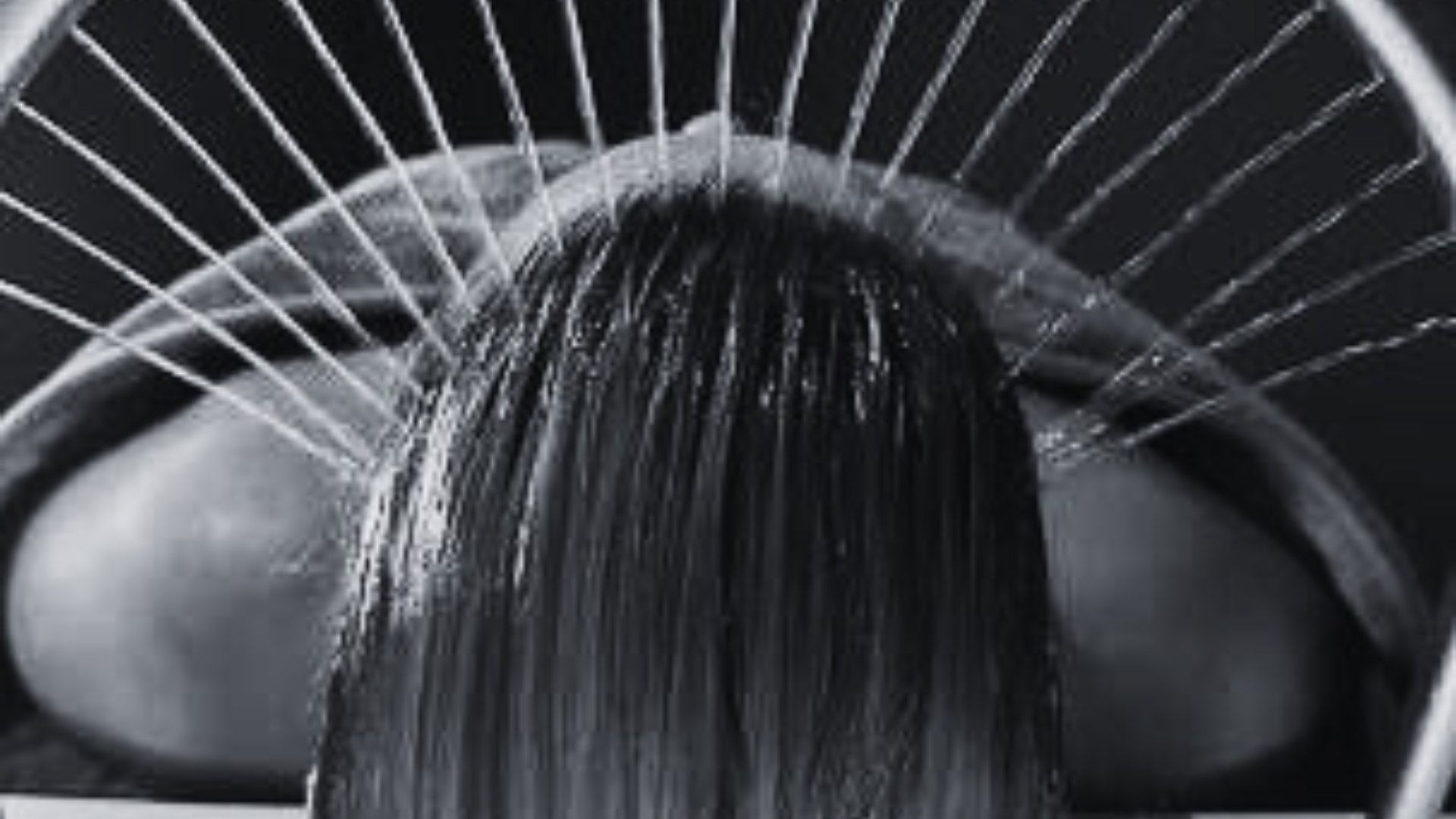 A woman is brushing her long hair with a wooden comb.