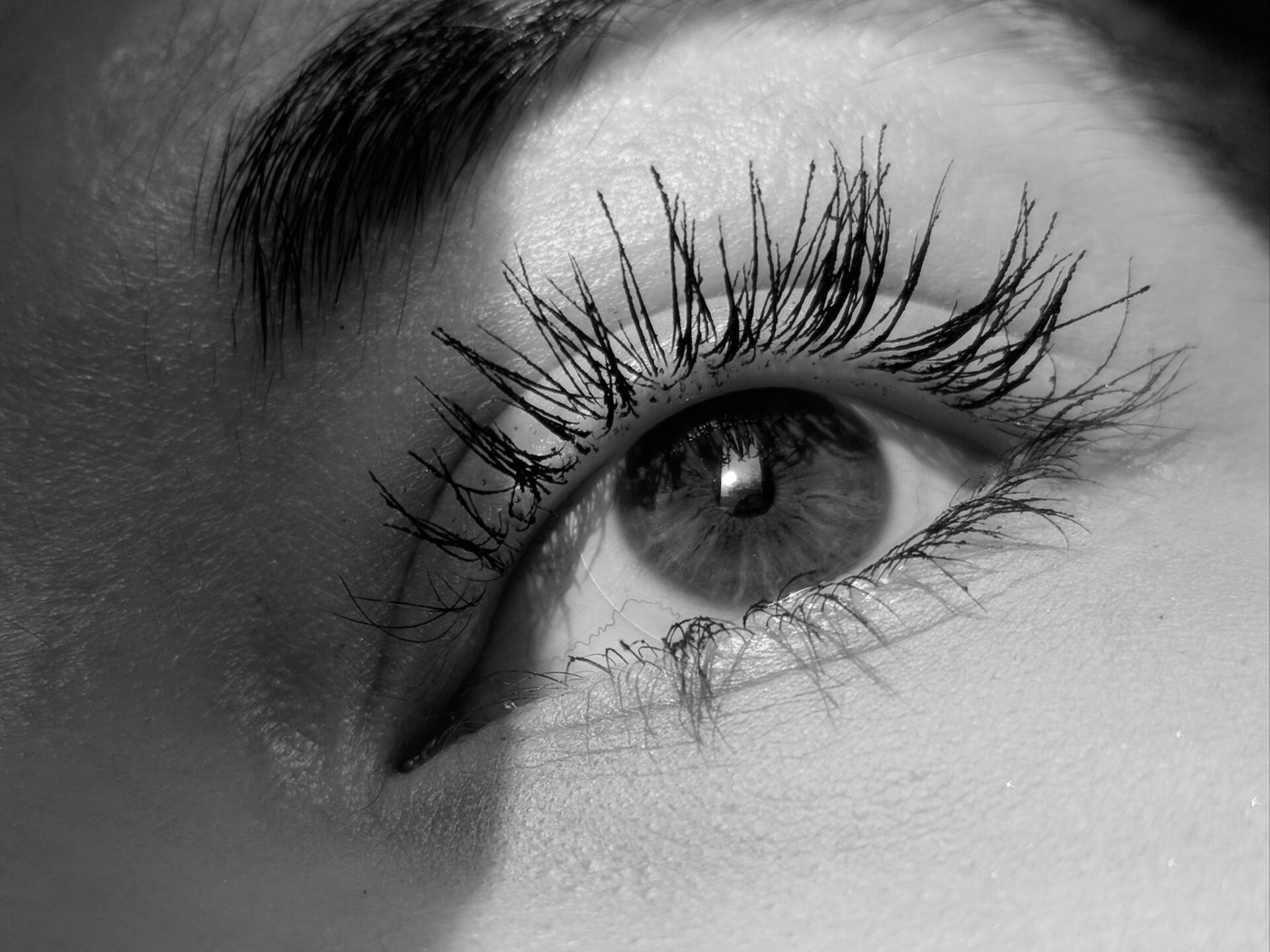 A close up of a woman 's eye with long eyelashes.