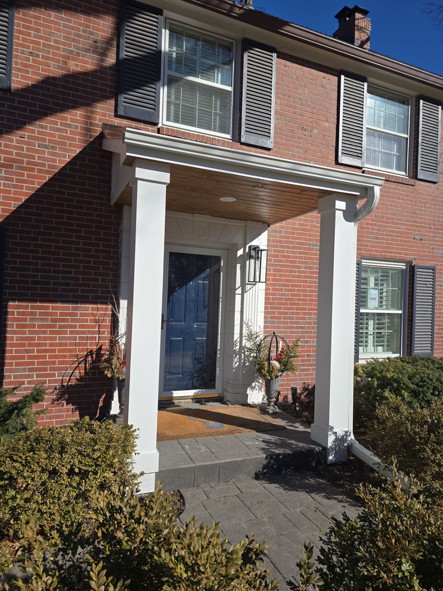 A brick house with a porch and a blue door