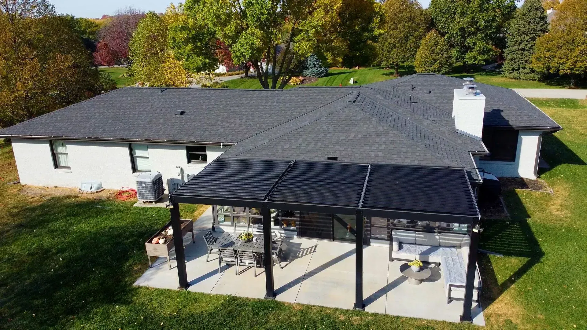 An aerial view of a house with a pergola on the backyard.