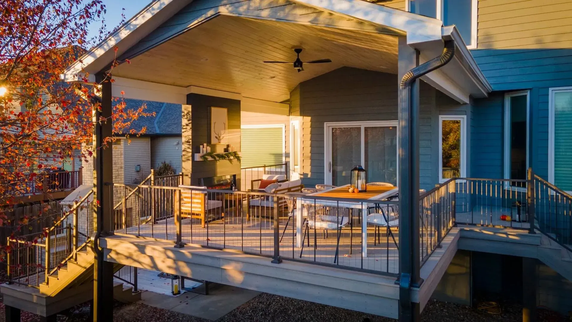 There is a large porch with a table and chairs on it.