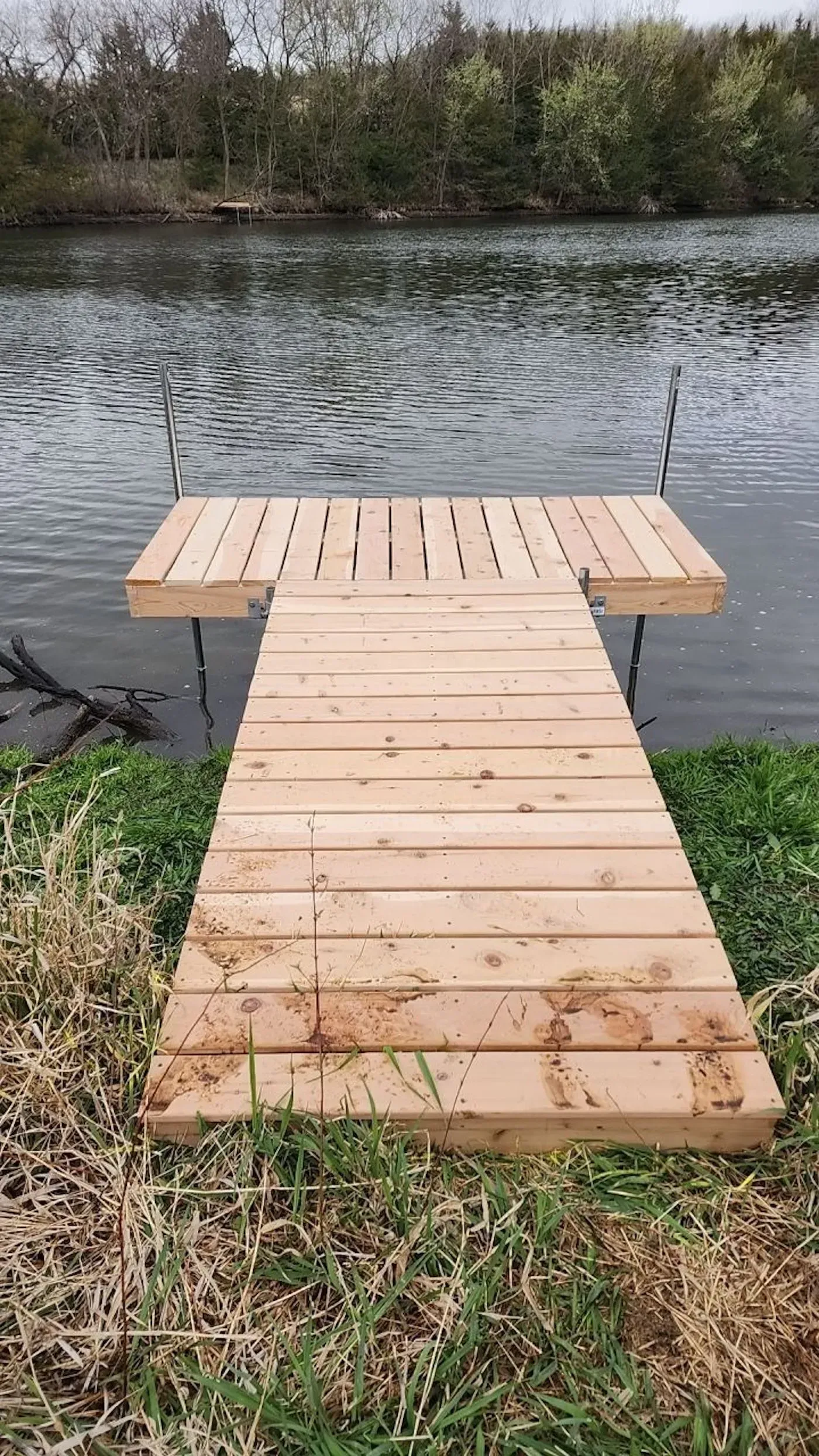 A wooden dock is sitting next to a lake.