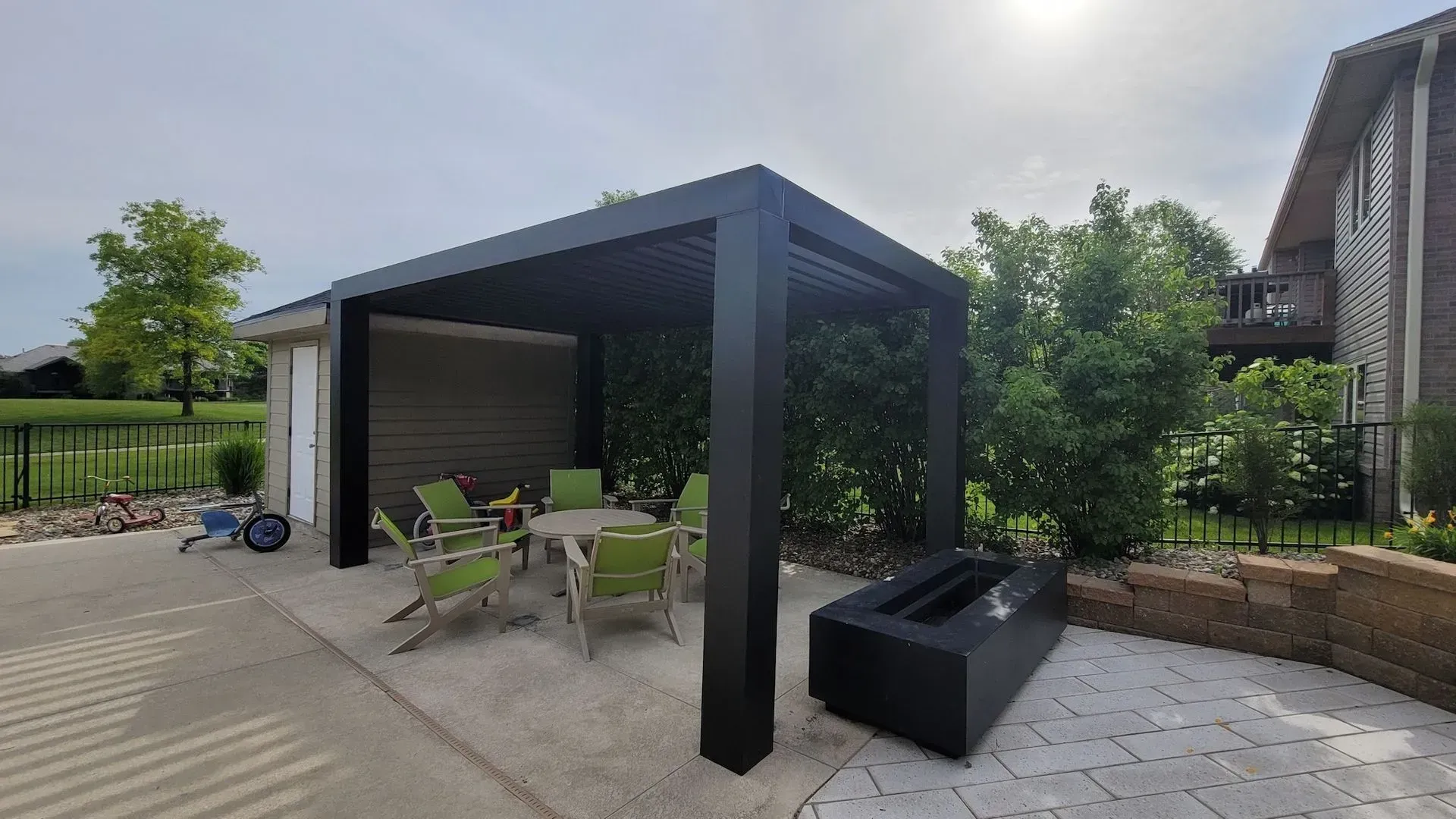 A patio with a table and chairs under a pergola.