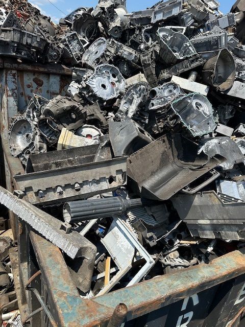 A large pile of scrap metal is sitting in a dumpster.