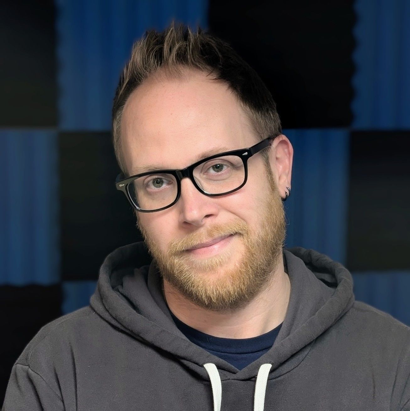 A man in a hoodie smiling