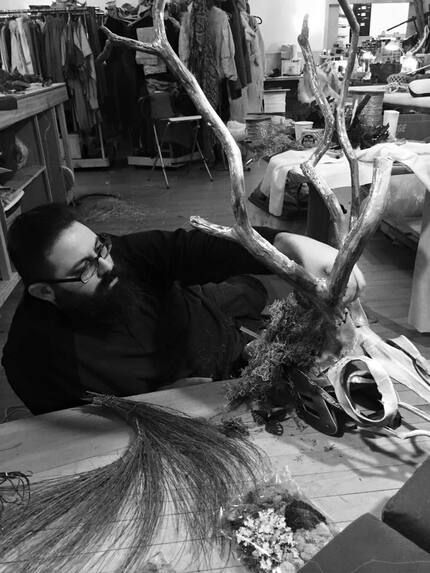 A man is laying on the floor holding a deer skull.