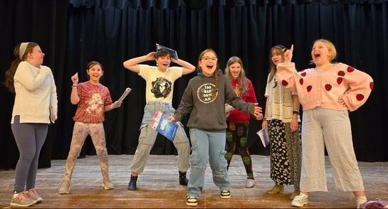 A group of young girls are standing on a stage.