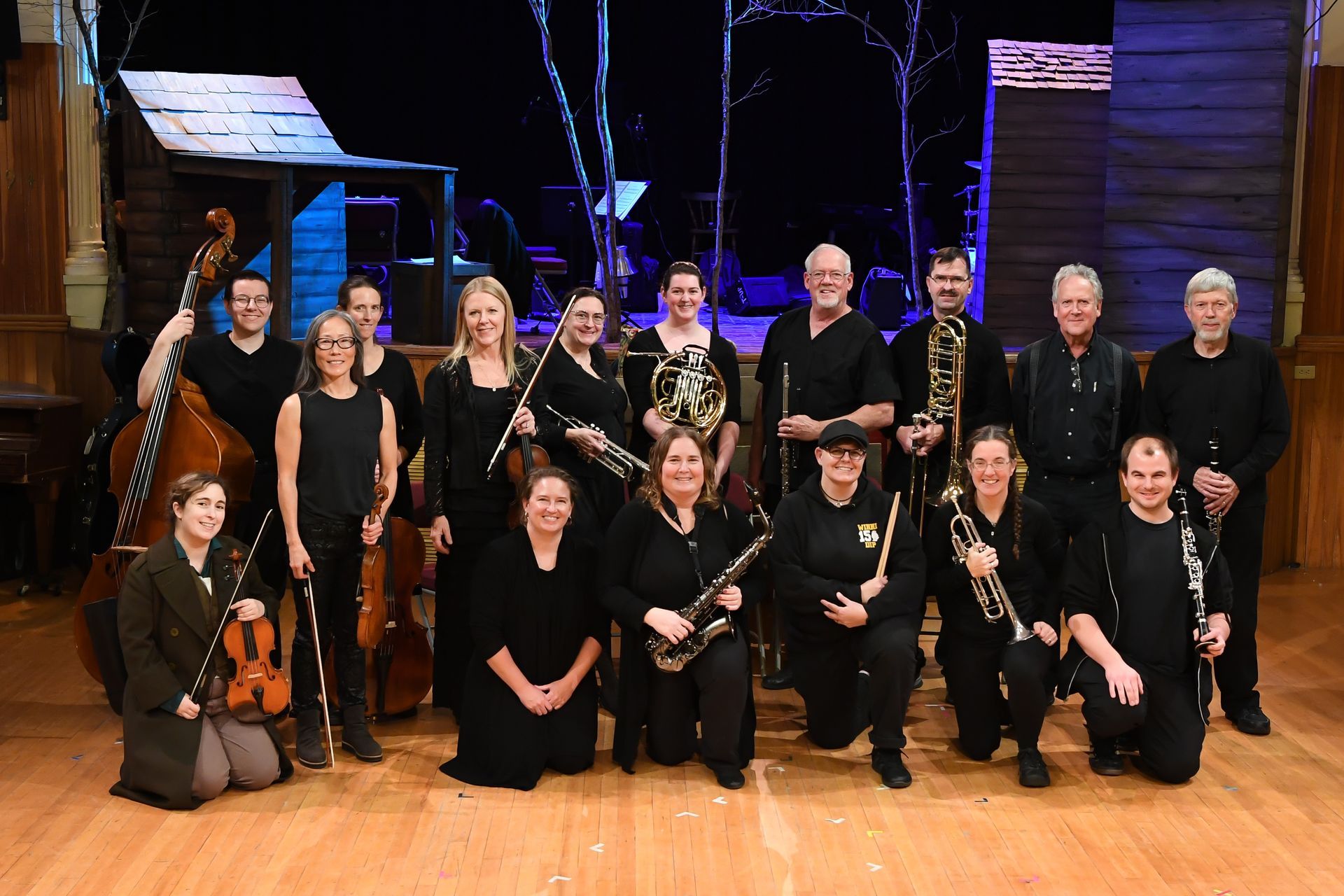 A group of musicians are posing for a picture on a stage.