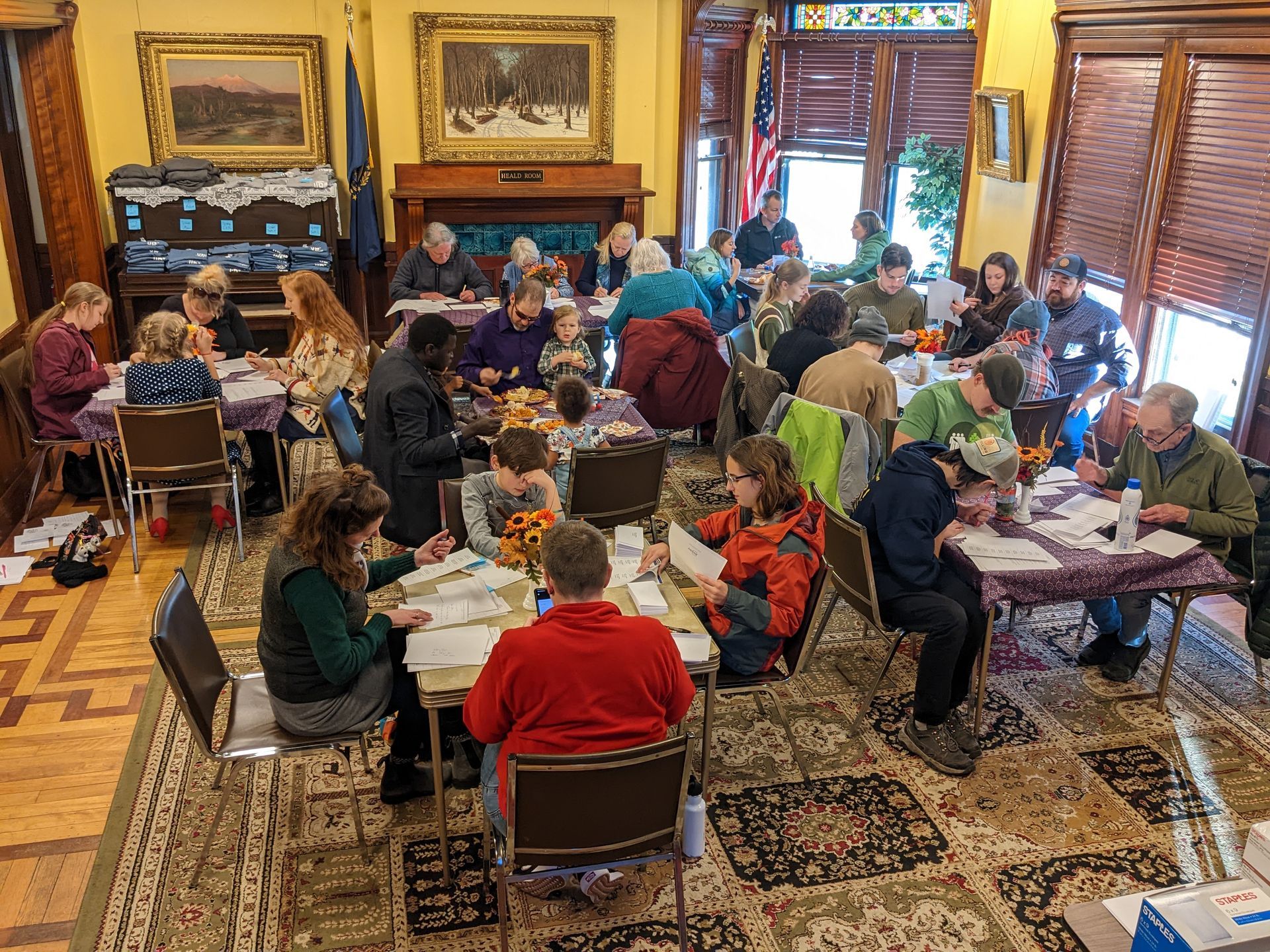 A large group of people are sitting at tables in a room.