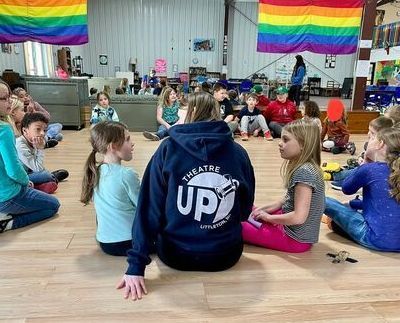 A group of children are sitting on the floor in a circle.