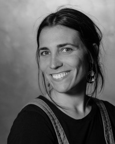 A woman is smiling in a black and white photo.