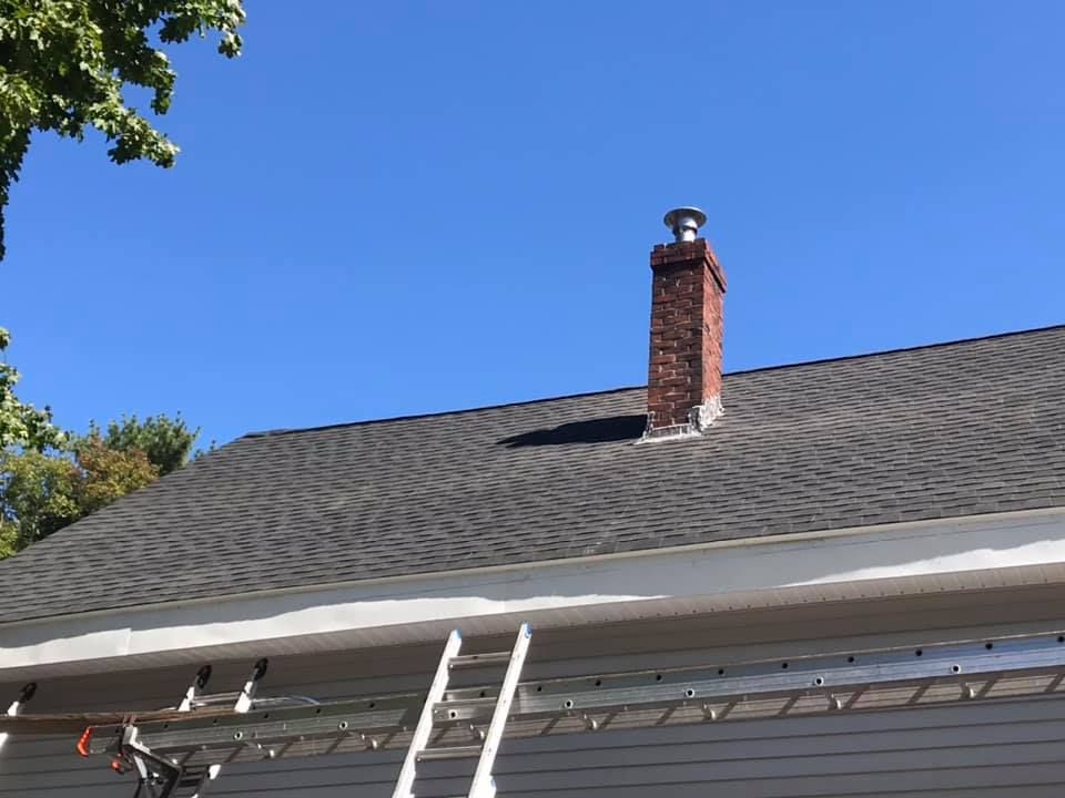 Rooftop with asphalt shingles and a metal gutter.
