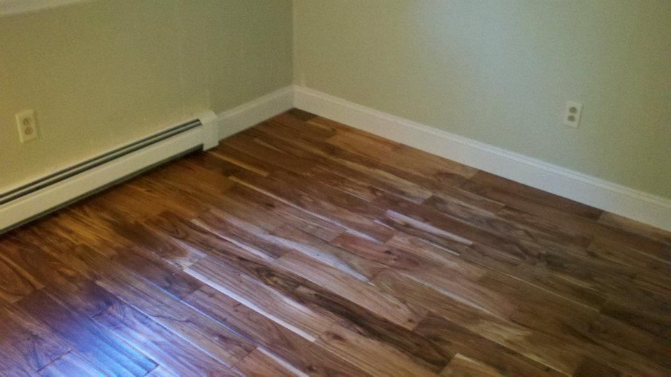 Grey composite deck boards being installed near wooden support posts.