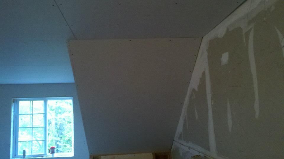 Roof of a mobile home being renovated, revealing exposed beams and insulation. 