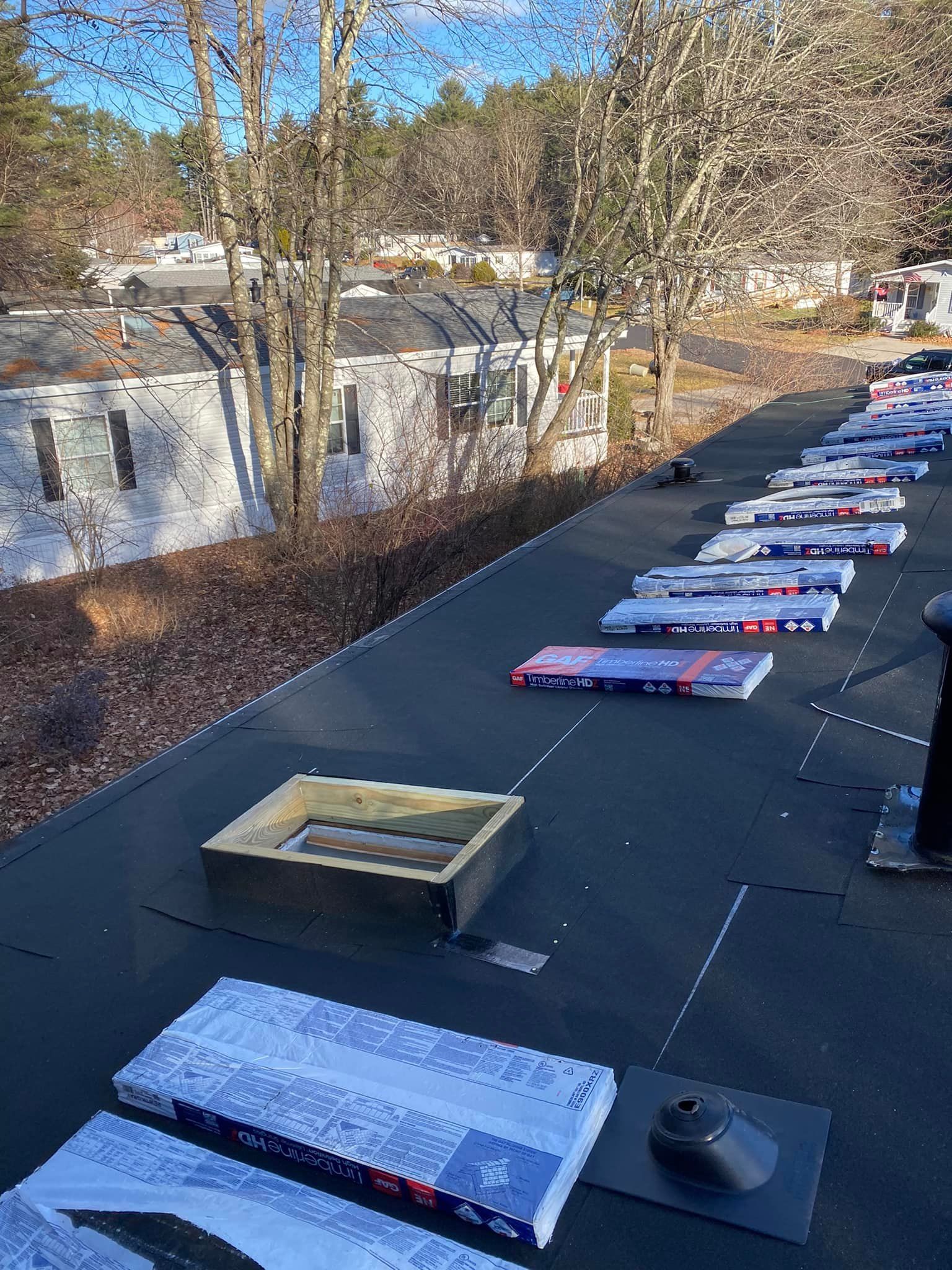 Cottage with screened-in porch, dark roof, and brick chimney under a clear blue sky.