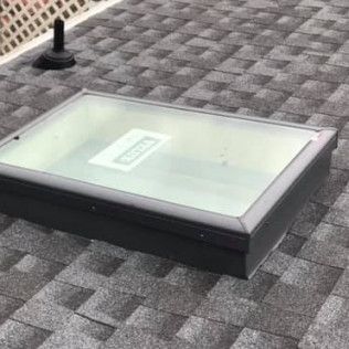 Skylight on a gray shingle roof.