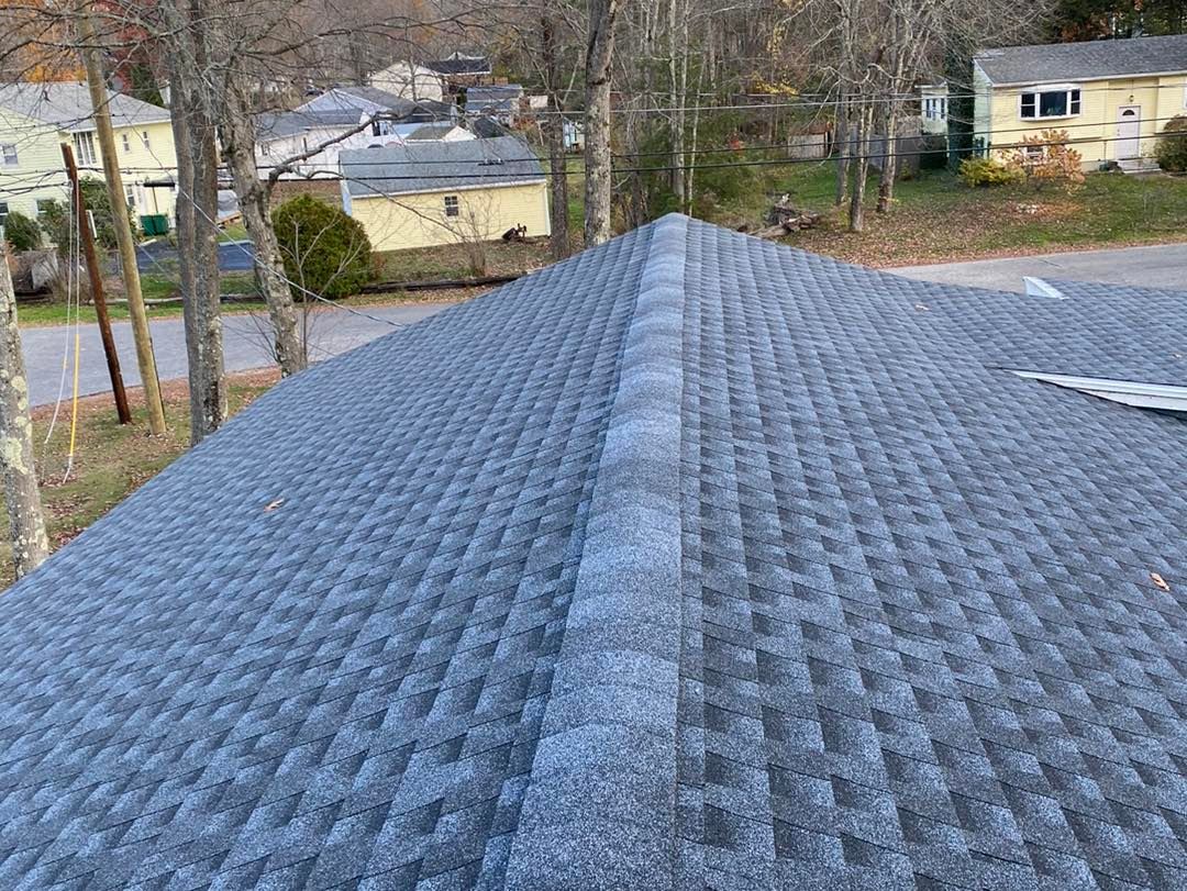 Gray asphalt shingle roof with a central ridge. 