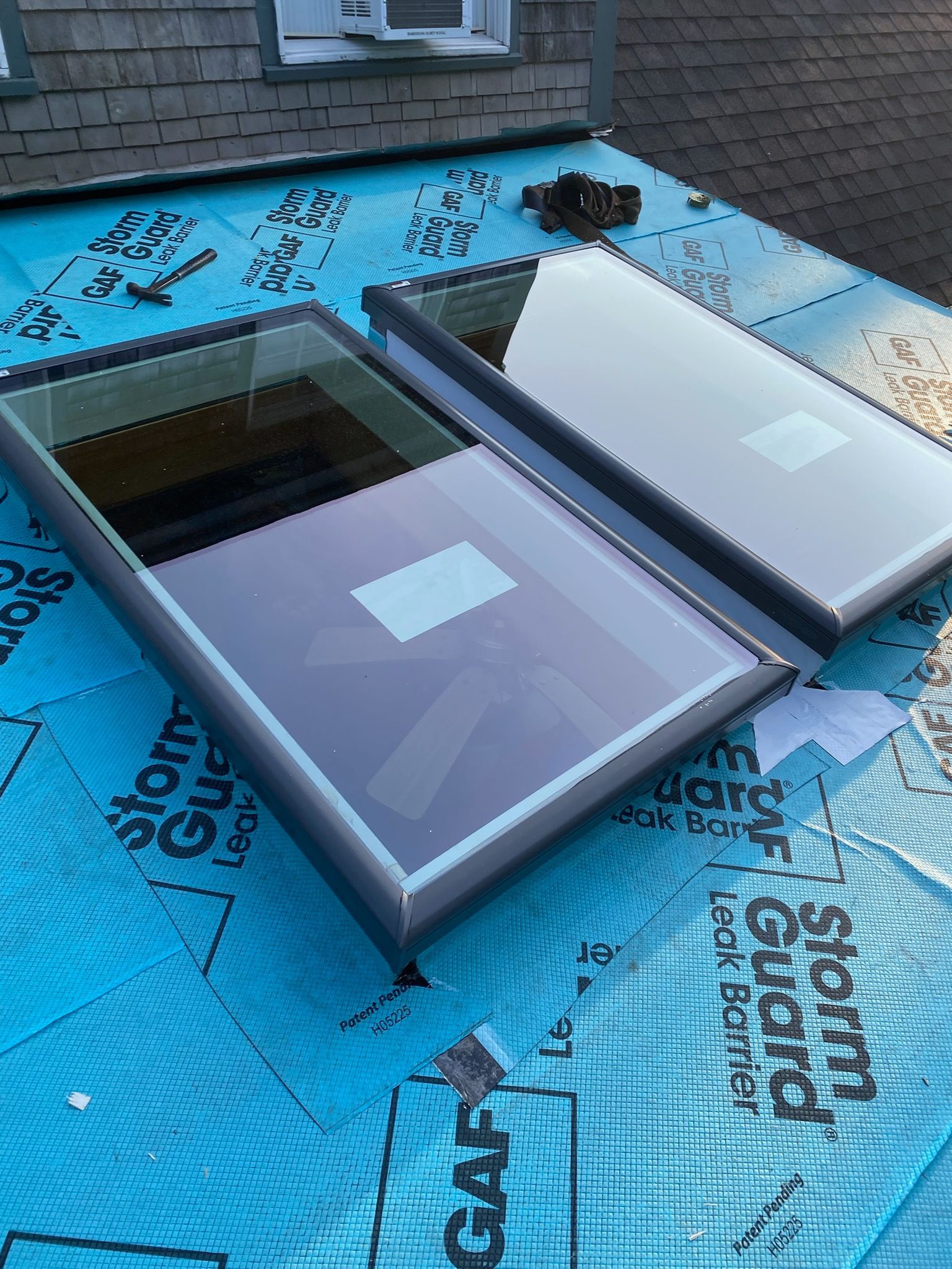 Gutter along a dark shingle roof with ladder visible.