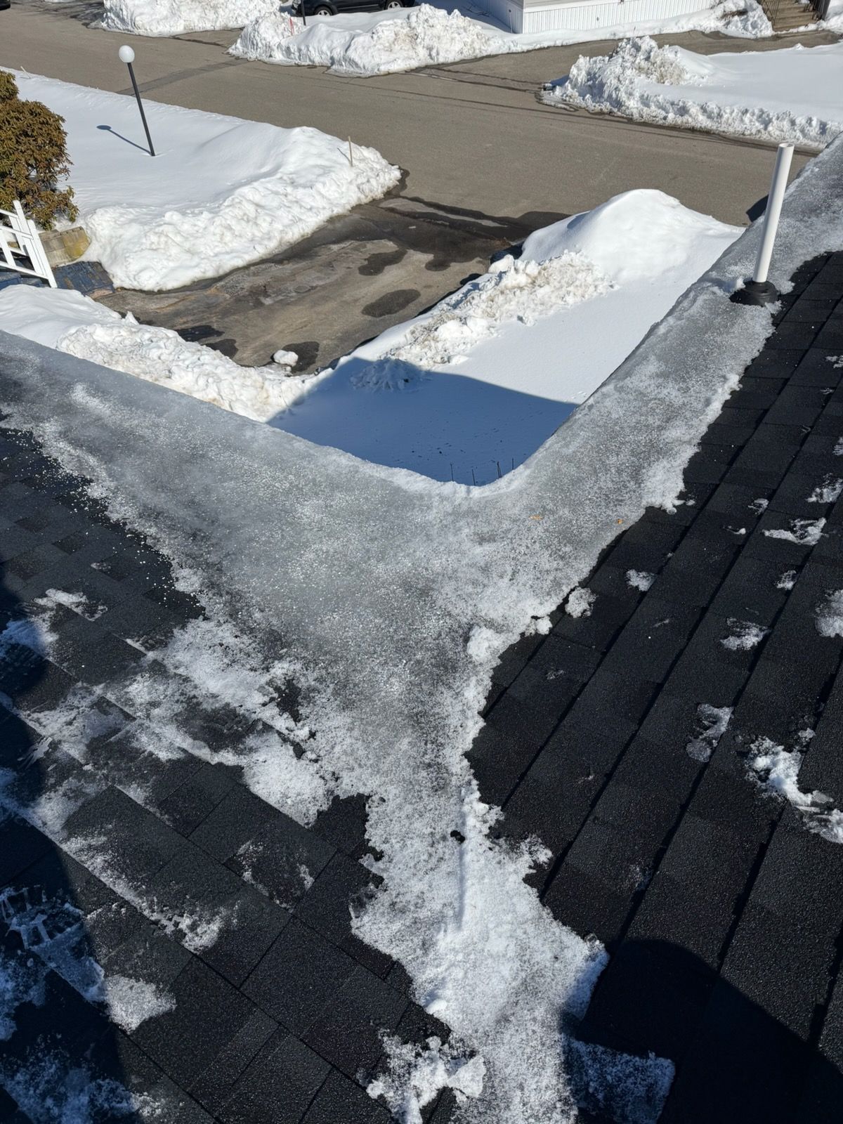 Cottage with screened-in porch, dark roof, and brick chimney under a clear blue sky.