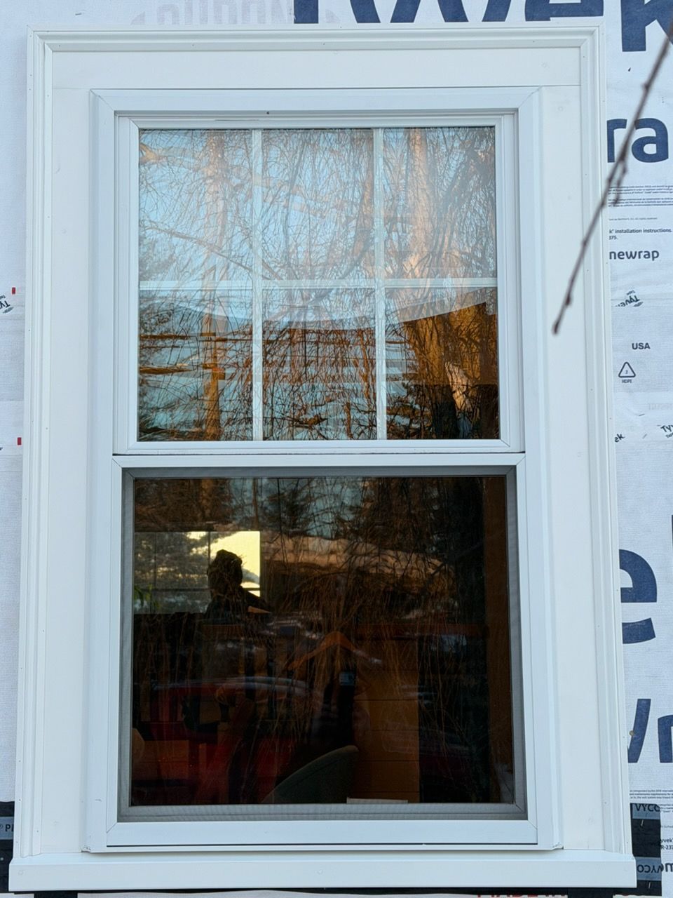 Gutter along a dark shingle roof with ladder visible.