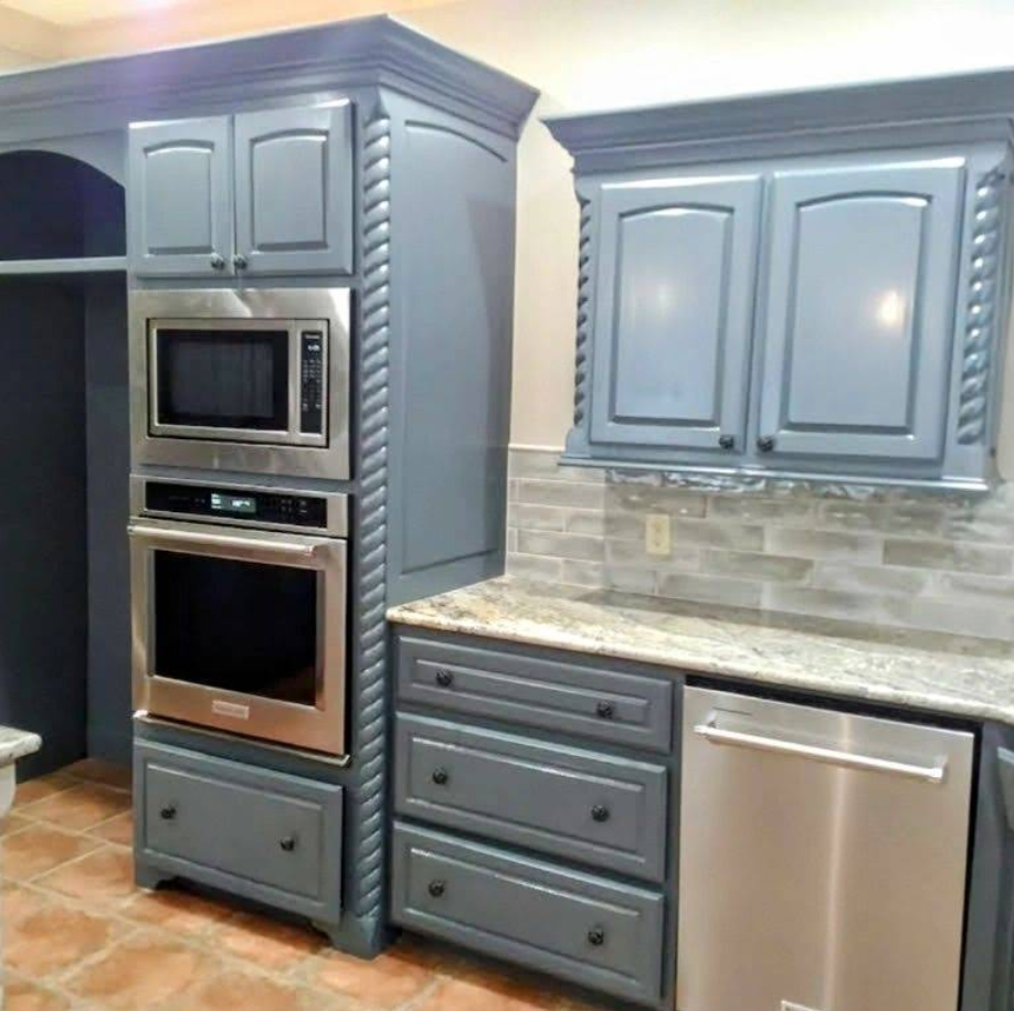 Blue kitchen cabinets with stainless steel appliances and granite countertop.