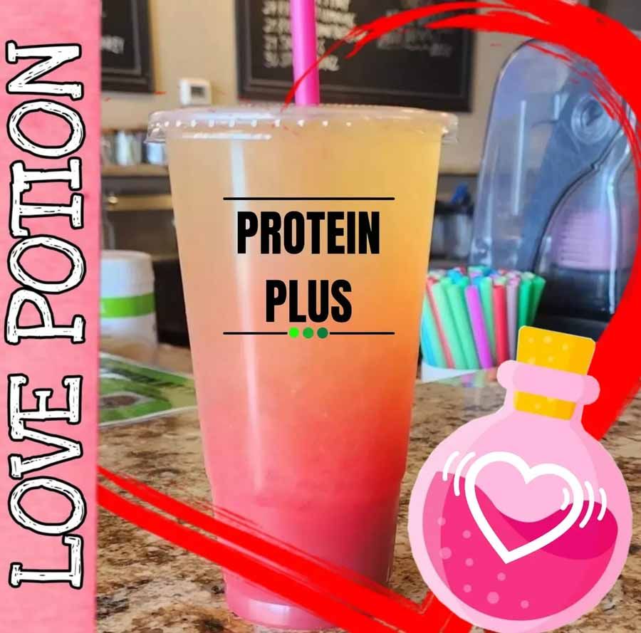 A layered pink and yellow drink in a clear cup with 