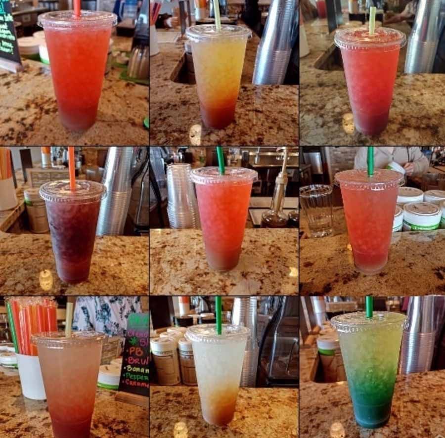 Nine colorful iced drinks in clear plastic cups on a speckled countertop, each with a straw.