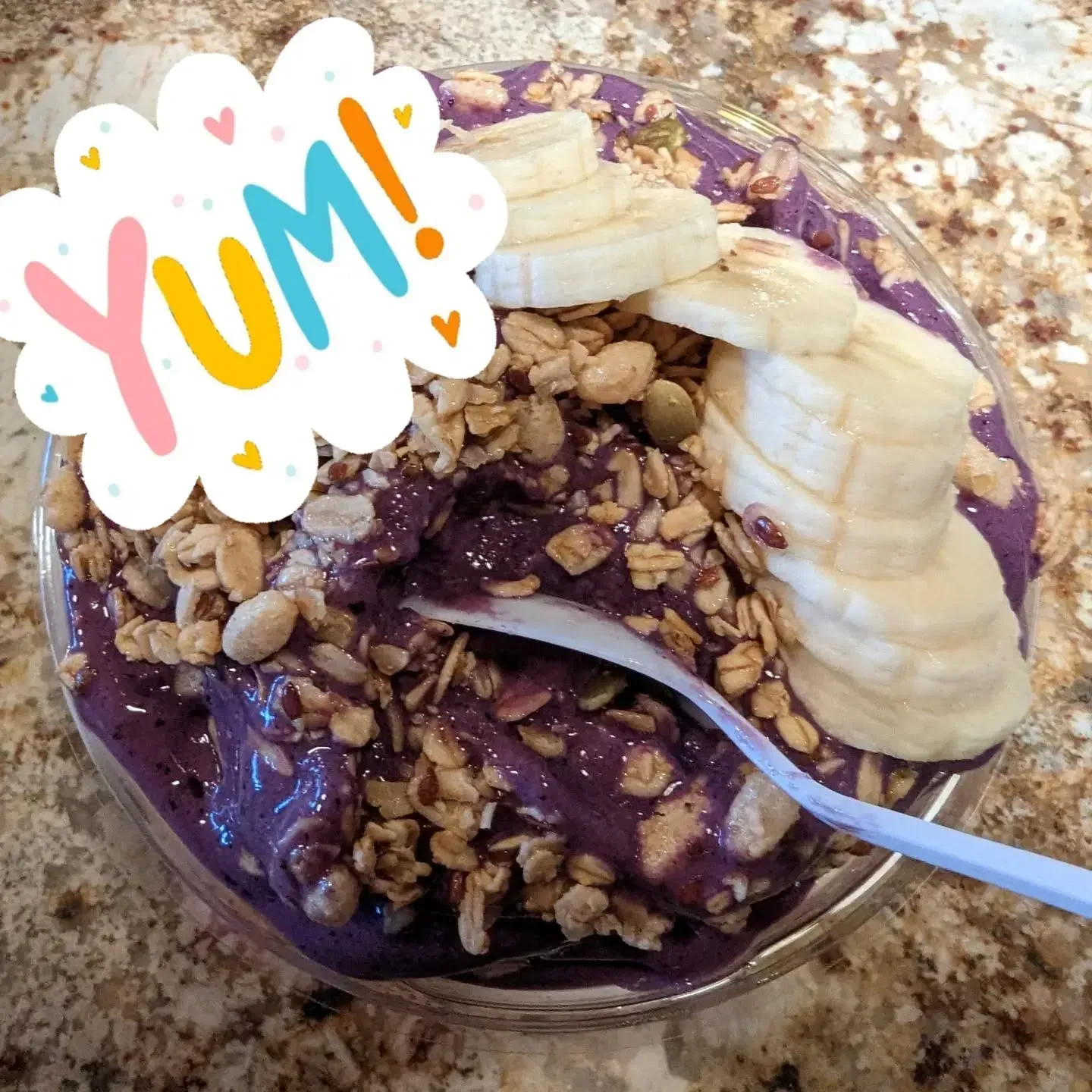 Acai bowl with granola and banana slices, topped with a 