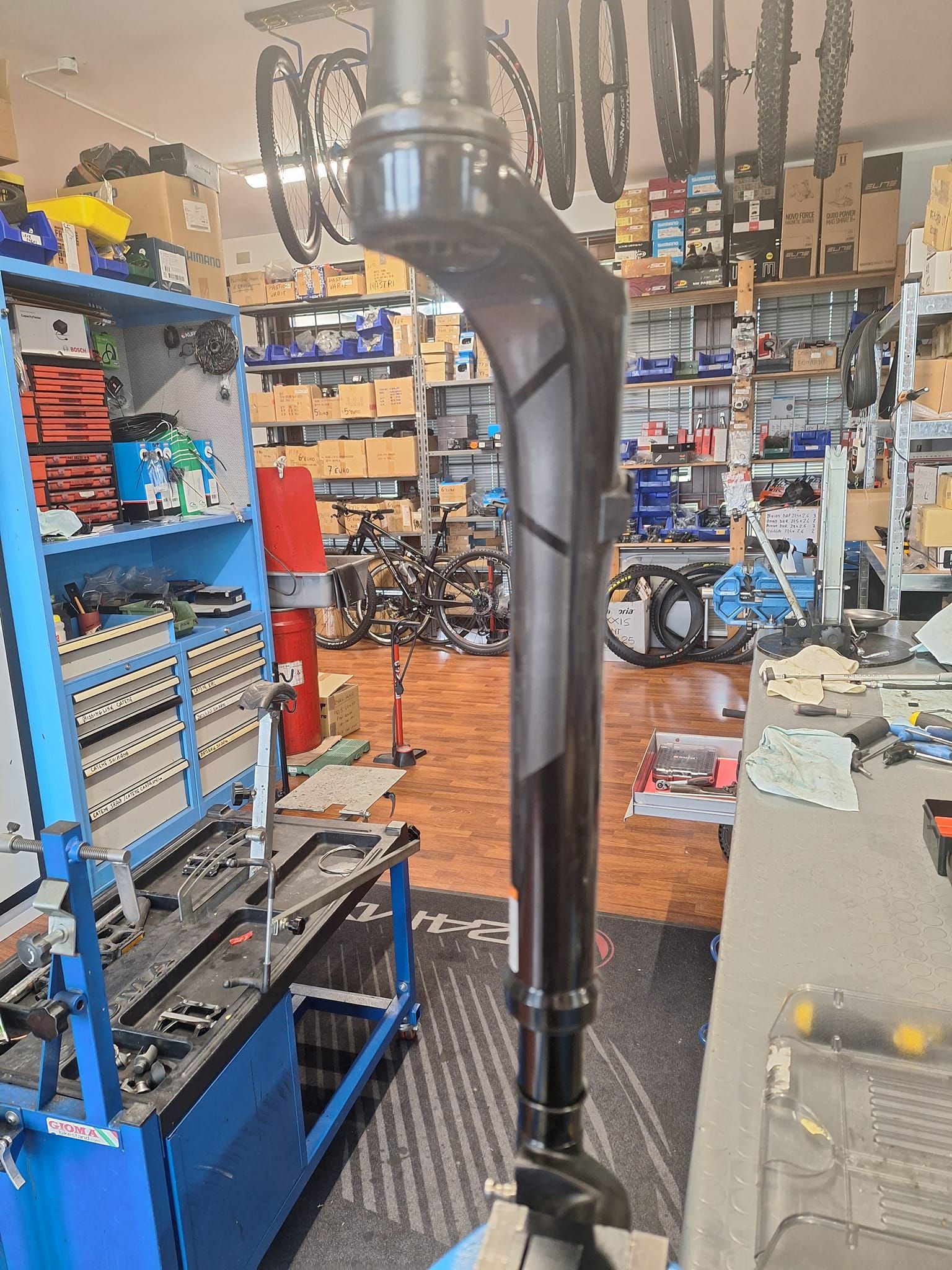 Una forcella per bicicletta è appoggiata su un tavolo in un negozio di biciclette.