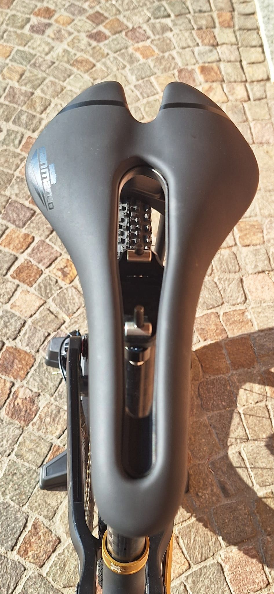 Primo piano di una sella di bicicletta su un marciapiede in mattoni.
