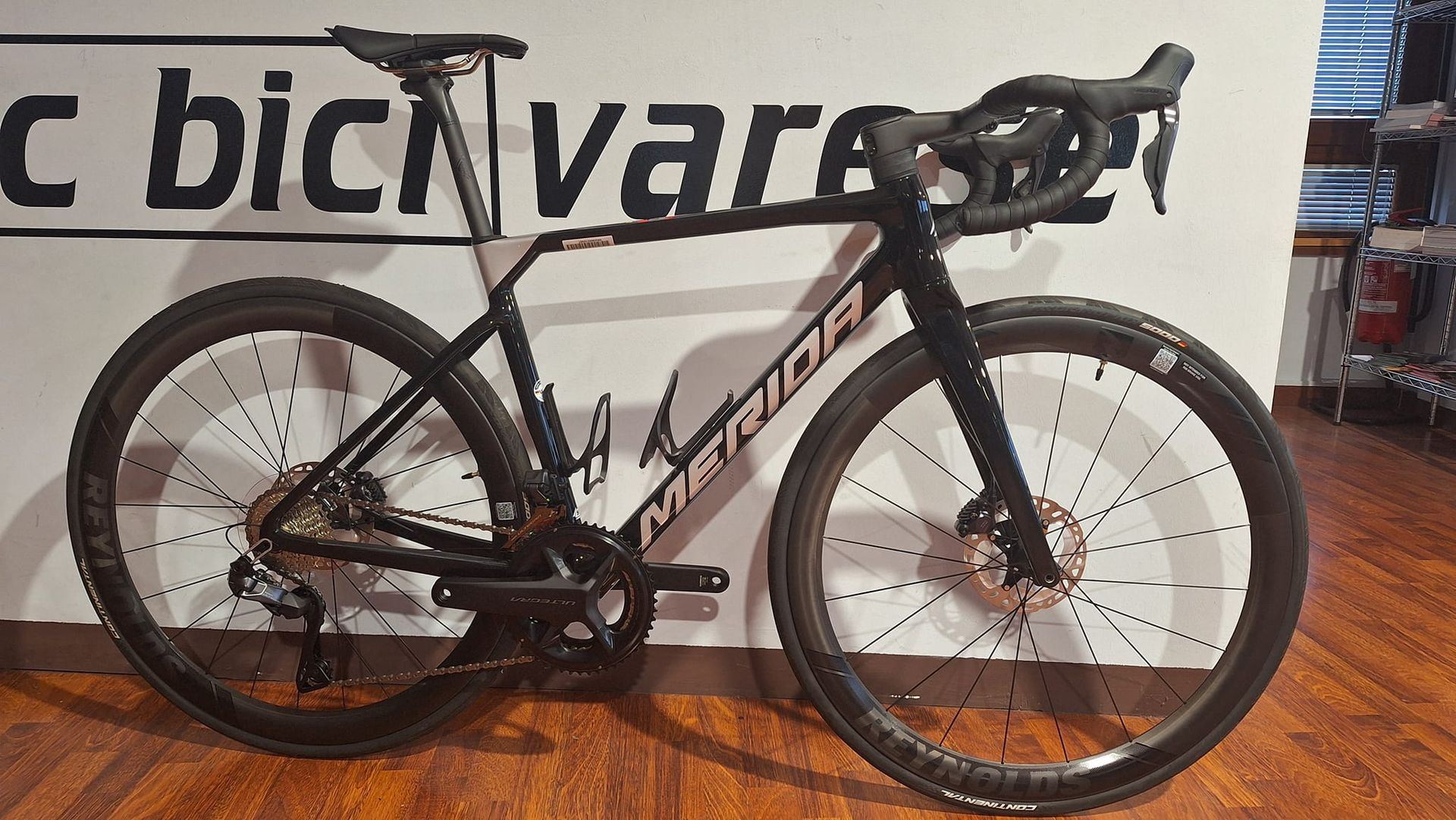 Una bicicletta è parcheggiata davanti a un cartello che dice bicivares