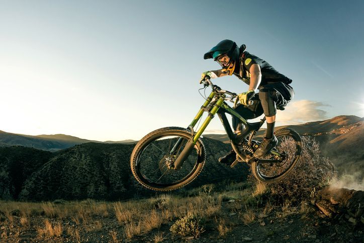 Una persona sta pedalando su una mountain bike su una strada sterrata.