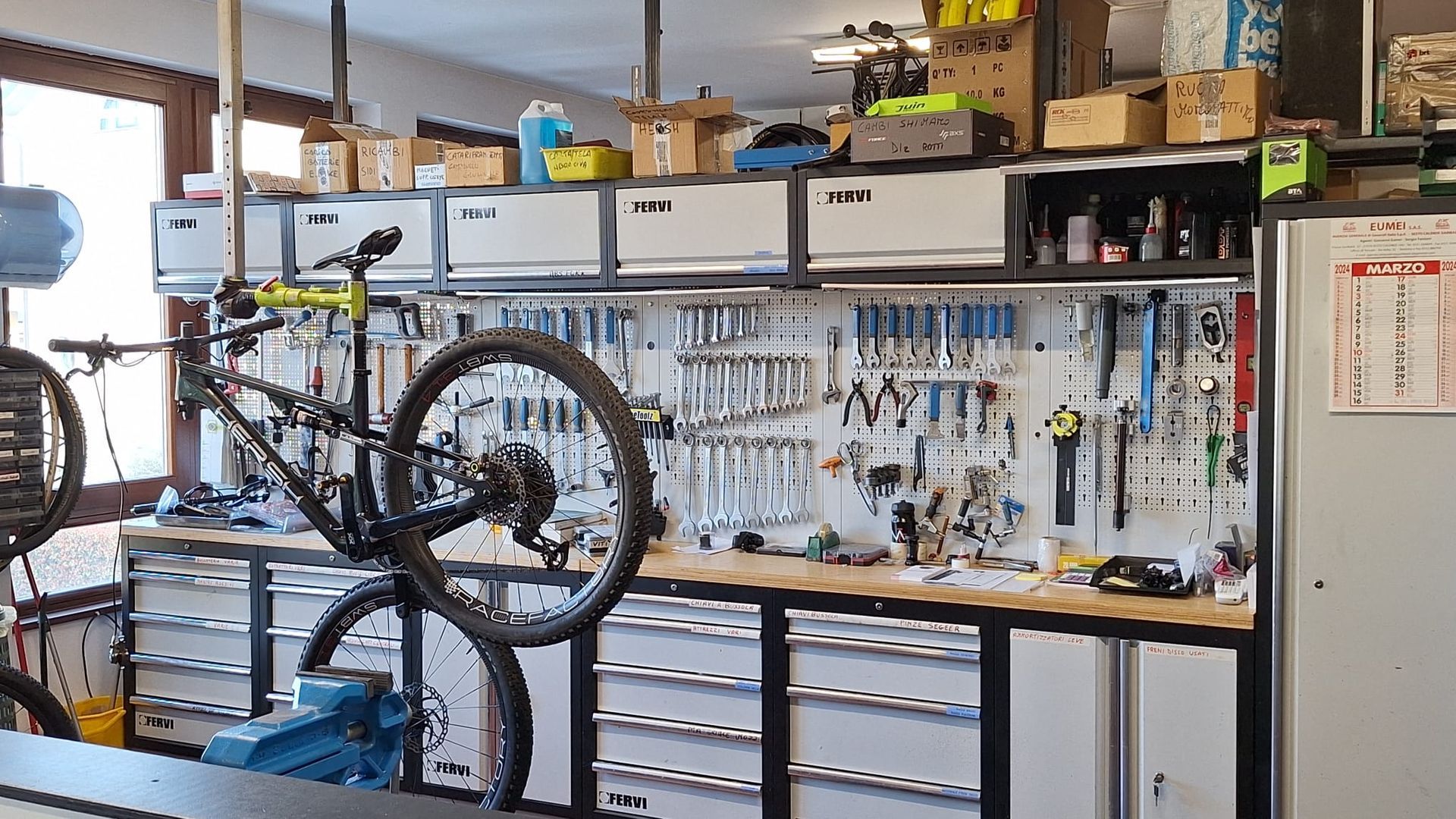 Una bicicletta è appesa a un portabici in un'officina.