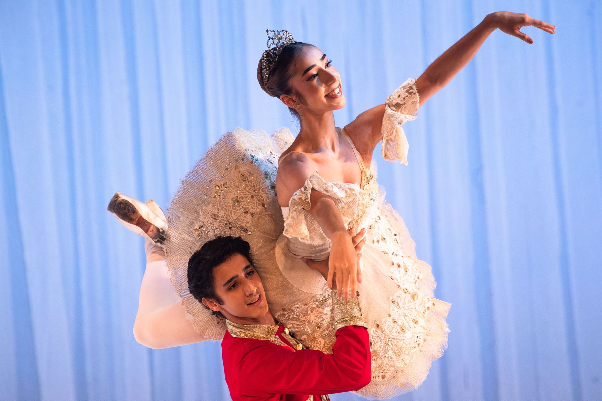 Um homem está segurando uma bailarina nos braços em um palco.