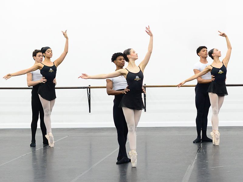 Um grupo de jovens bailarinas está praticando em um estúdio de dança.