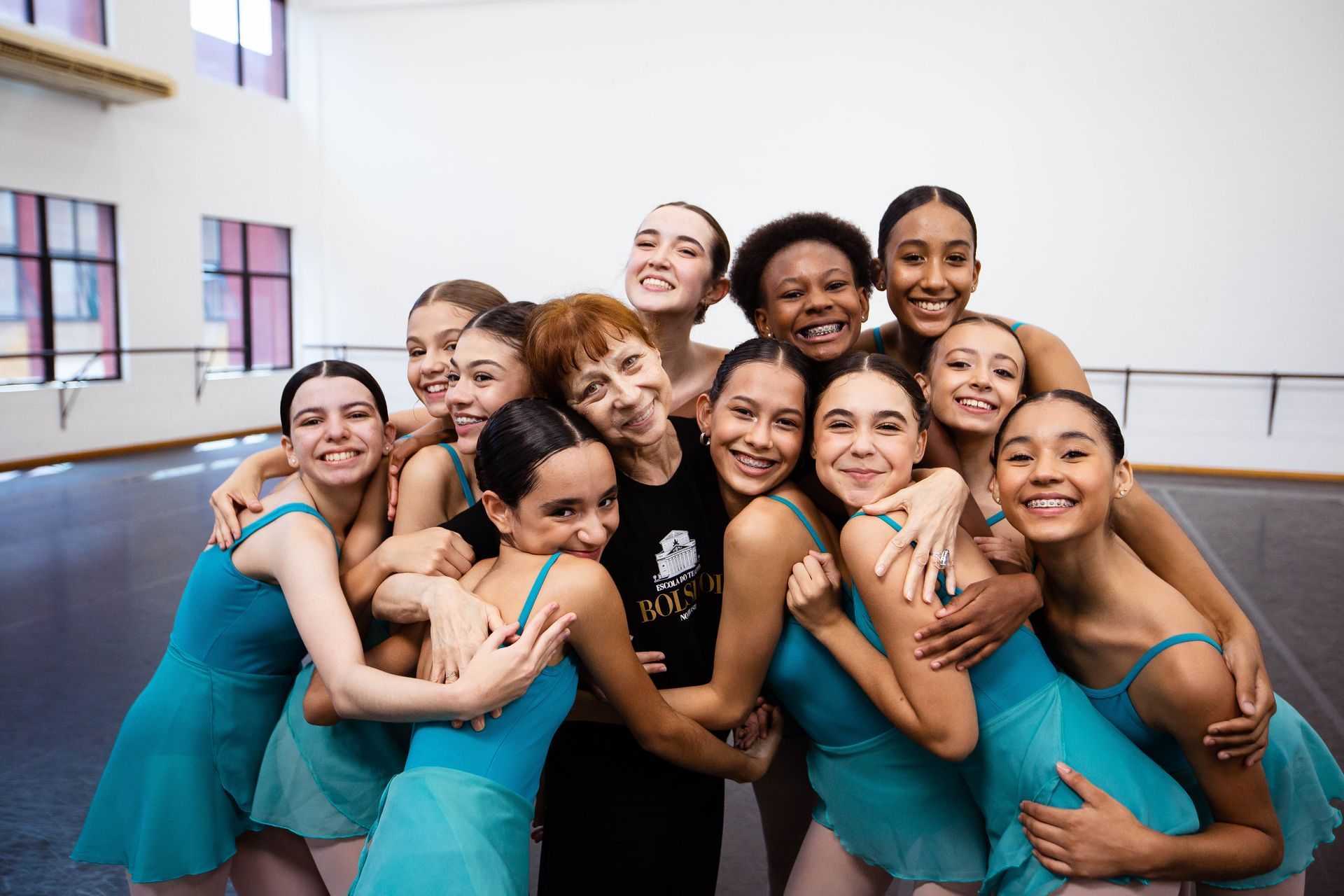 Um grupo de jovens mulheres está posando para uma foto em um estúdio de dança.