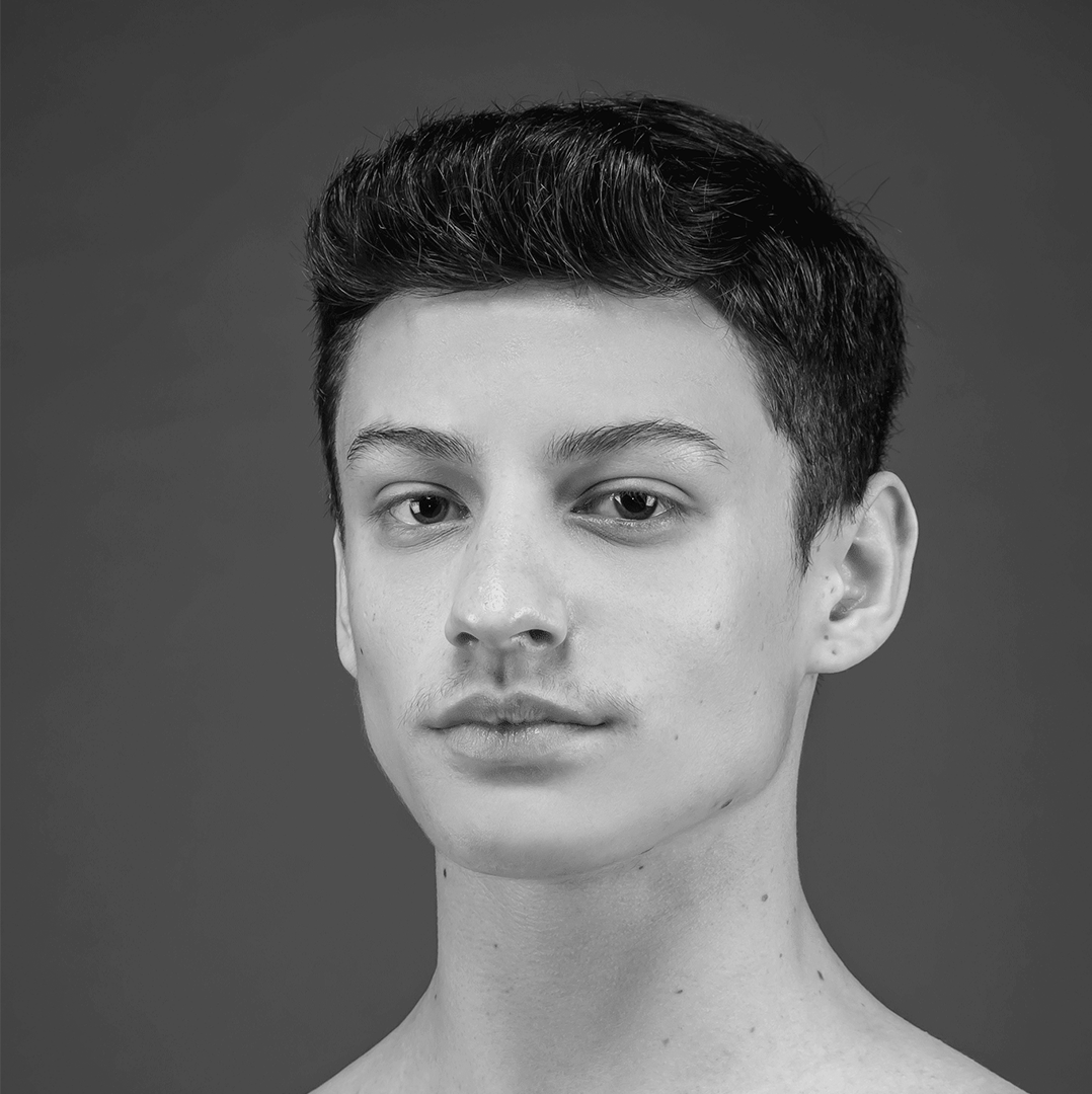 Um jovem sem camisa está olhando para a câmera em uma foto em preto e branco.