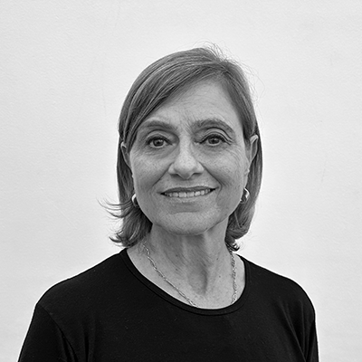 Uma foto em preto e branco de uma mulher vestindo uma camisa preta e sorrindo.