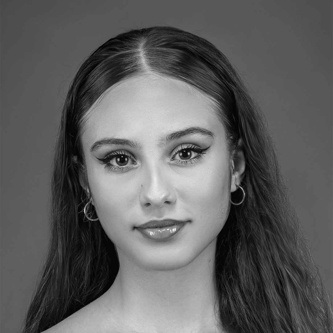 Uma foto em preto e branco de uma mulher com cabelos longos e brincos de argola.