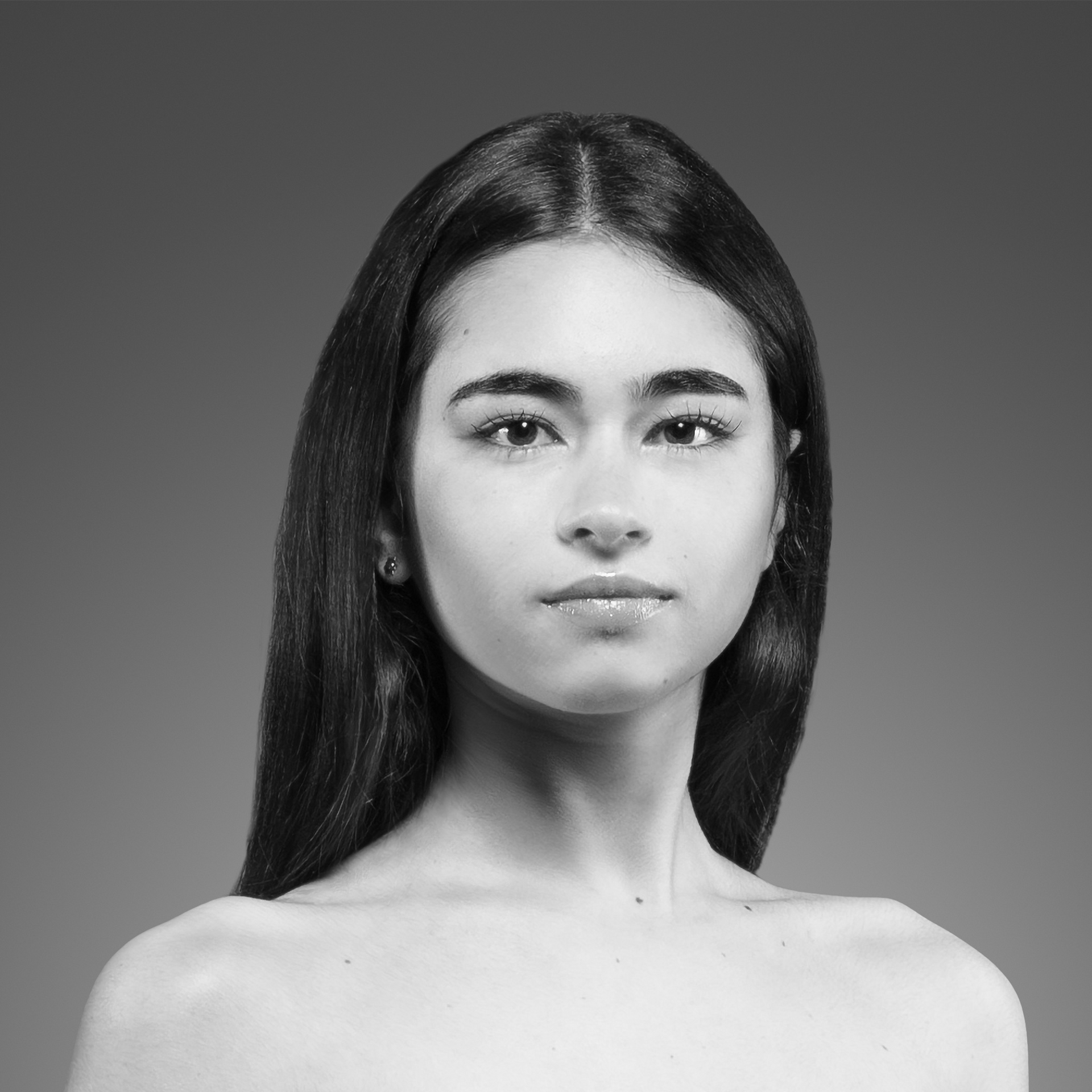 Uma foto em preto e branco de uma mulher com cabelos longos e sem camisa.