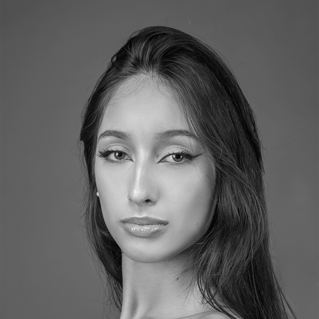 Uma foto em preto e branco de uma mulher com cabelos longos olhando para a câmera.