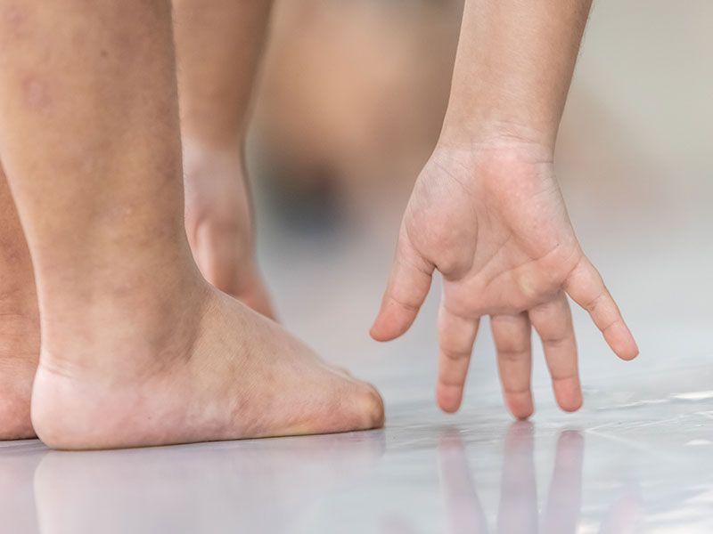 Um close dos pés e mãos descalços de uma criança.