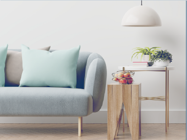 淺藍色沙發配靠墊、木質邊桌、綠植和吊燈，靠著白牆。